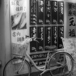 a bicycle against a wall with japanese writing